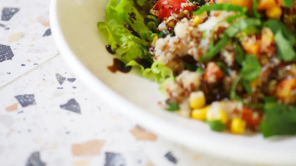 Nærbillede af grøn salat med salatblade, tomat og majs