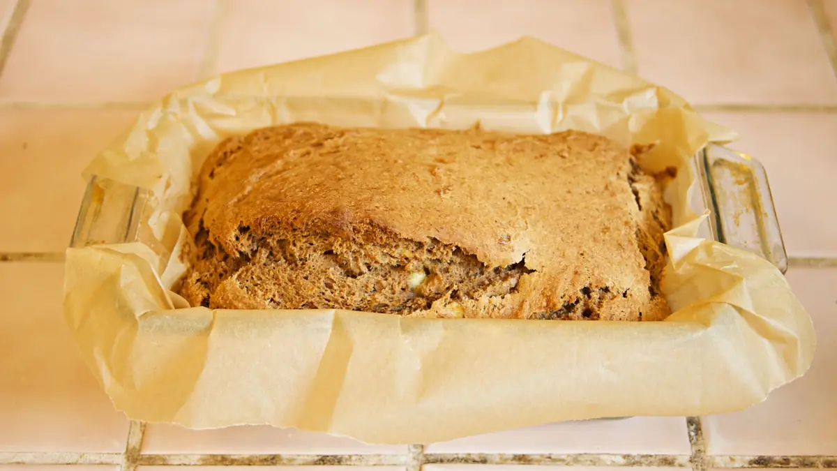 Hjemmebagt banankage i bageform med bagepapir, lige taget ud af ovnen