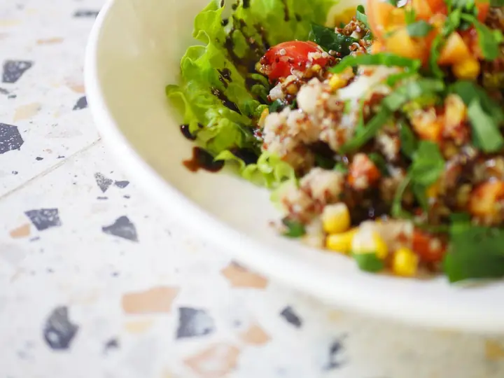 Nærbillede af grøn salat med salatblade, tomat og majs