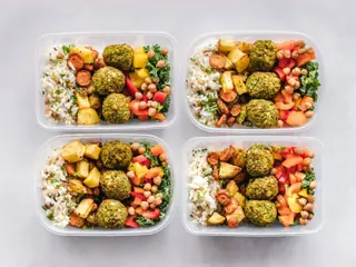 Tre madkasser med kikærter, ris og grøntsager set ovenfra