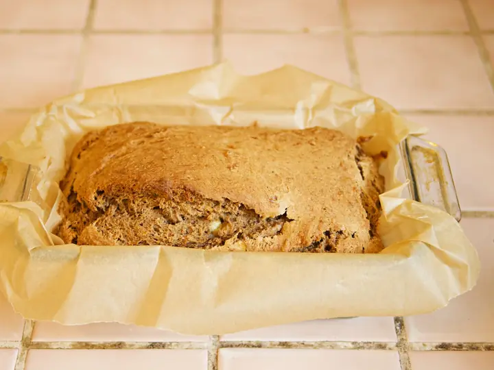 Hjemmebagt banankage i bageform med bagepapir, lige taget ud af ovnen